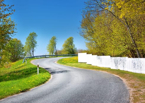 Car on asphalt road in beautiful spring day at countryside