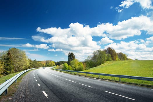 Car on asphalt road in beautiful spring day at countryside