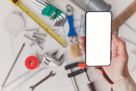 Smartphone with blank screen with drawing and building supplies in the background