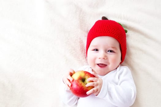 7 month old baby lying inbed with apple