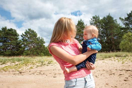young woman and baby at the beach near sea