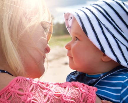 young woman and baby at the beach near sea