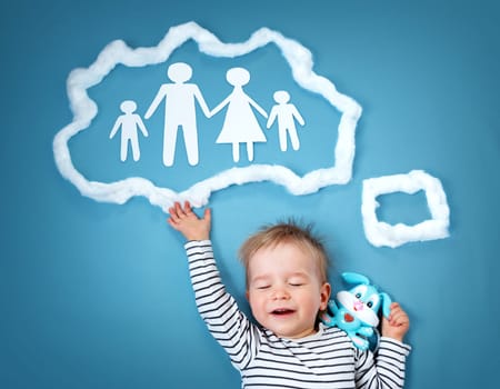 Little baby boy dreaming of a family on blue background