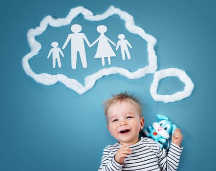 Little baby boy dreaming of a family on blue background