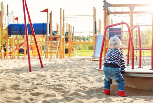 Little boy playing on playground in the spring