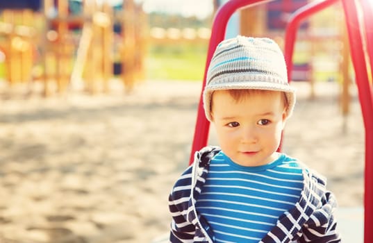 Little boy playing on playground in the spring