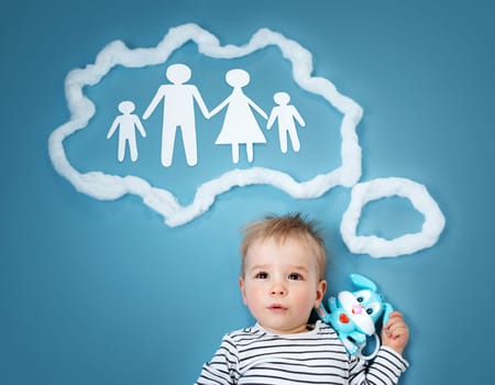 Little baby boy dreaming of a family on blue background