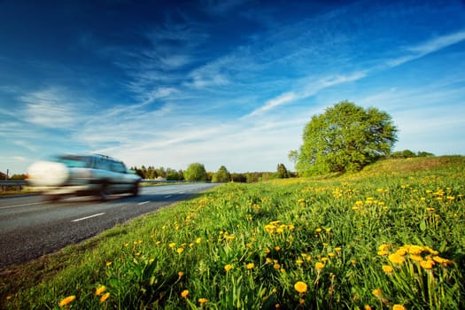 Car on asphalt road in beautiful summer evening at countryside