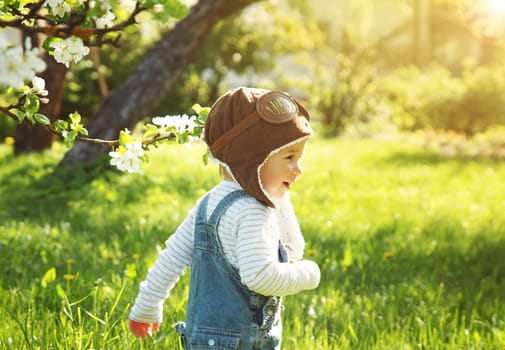 Boy playing in aviator hat in the garden