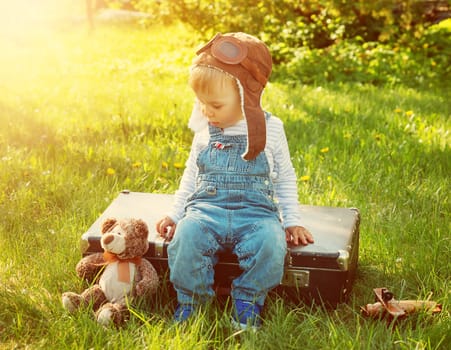 Boy playing in aviator hat in the garden