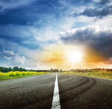 asphalt road view in countryside on sunny summer day with dramatic clouds
