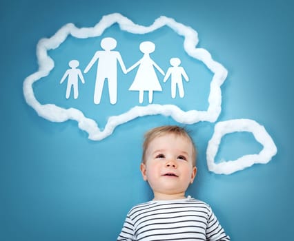 Little baby boy dreaming of a family on blue background