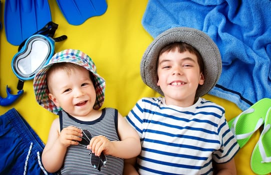 little boy with sunglasses in hat on yellow blanket