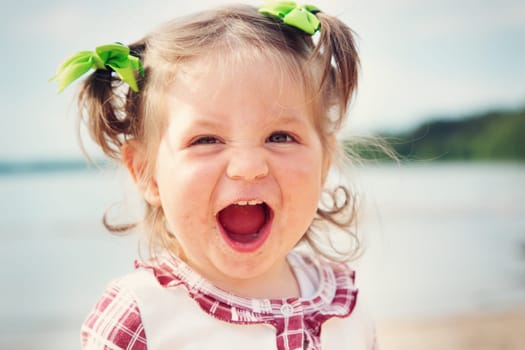 Funny one year old girl shouting at the sea