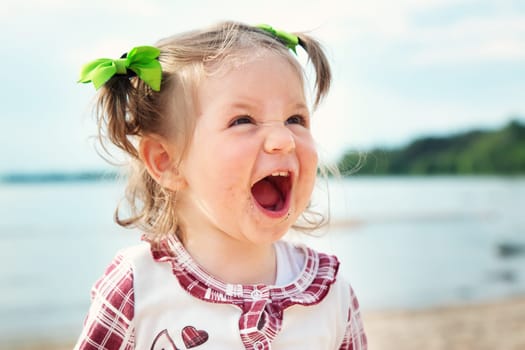Funny one year old girl shouting at the sea