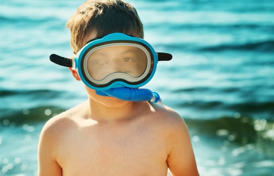Child on the beach with swimming mask. Boy on vacation at sea