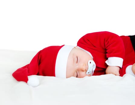 little baby sleeping in red hat on white blanket. Eight month old child in santa costume