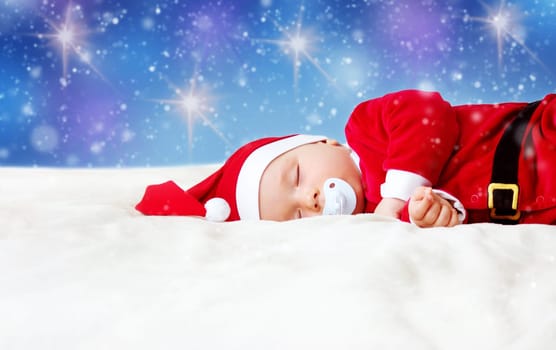 little baby sleeping in red hat on white blanket. Eight month old child in santa costume