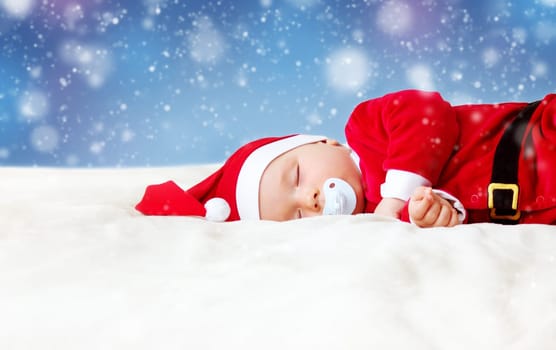 little baby sleeping in red hat on white blanket. Eight month old child in santa costume