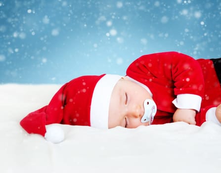 little baby sleeping in red hat on white blanket. Eight month old child in santa costume
