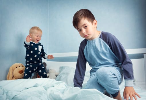 Brothers sitting in the bed in pyjamas