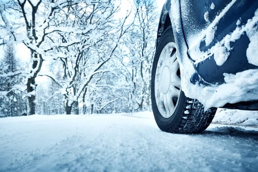 Car tires on winter road covered with snow