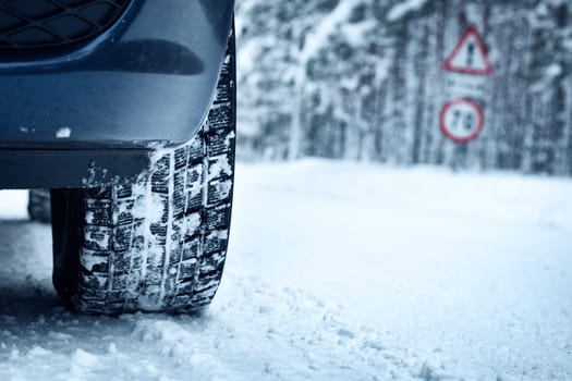 Car tires on winter road covered with snow