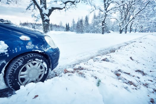 Car tires on winter road covered with snow