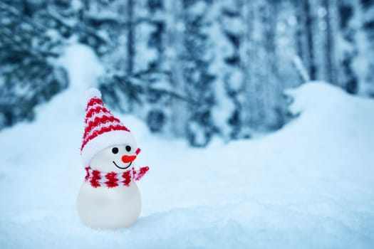 little snowman on soft snow in the forest in winter