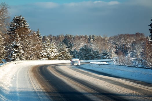 Car tires on winter road covered with snow