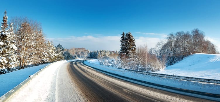 Asphalt road in snowy winter on beautiful frosty sunny day
