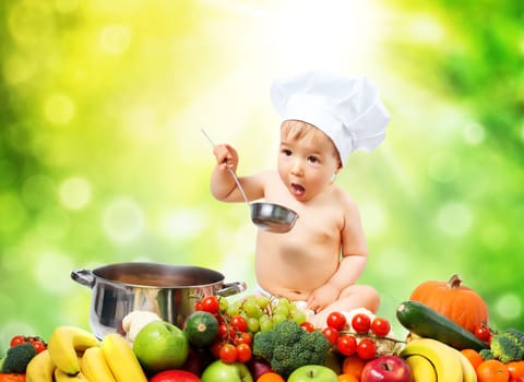Baby boy in chef hat sitting with cooking pan and raw vegetables