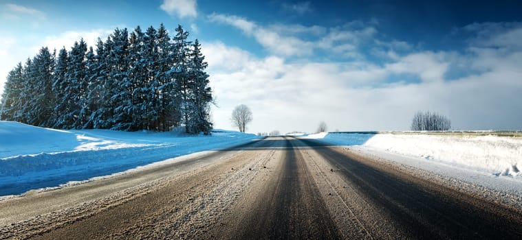 Asphalt road in snowy winter on beautiful frosty sunny day