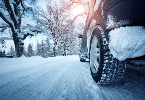 Car tires on winter road covered with snow