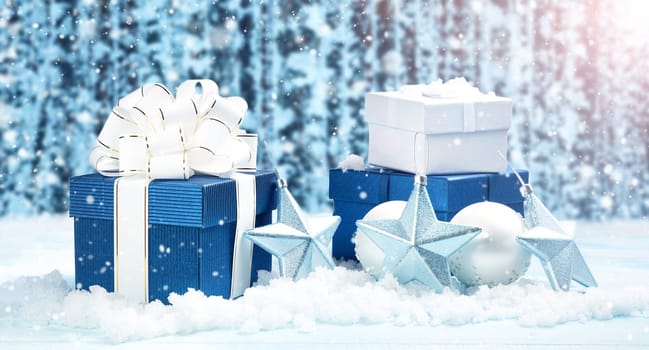 Blue gift boxes with christmas decoration on beautiful forest background