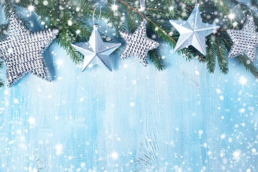 Christmas stars on wooden background with fir tree branches. Winter background