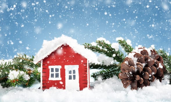 Small red house model covered with snow in winter