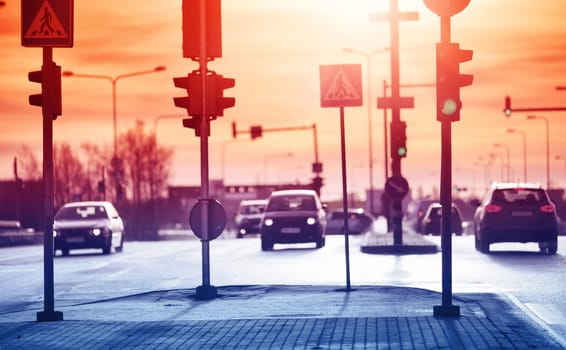 Cars moving on the road in city in early morning. View to the traffic with trafficlights and transport