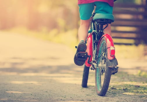 child on a bicycle at asphalt road in early morning