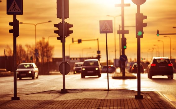 Cars moving on the road in city in early morning. View to the traffic with trafficlights and transport