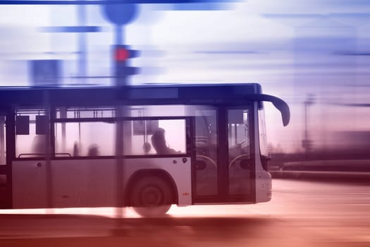 Bus moving on the road in city in early morning. View to the traffic with trafficlights and transport