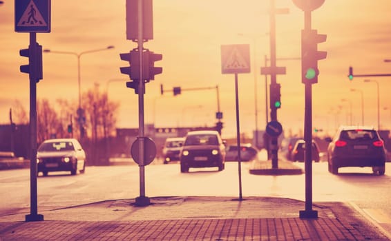 Cars moving on the road in city in early morning. View to the traffic with trafficlights and transport