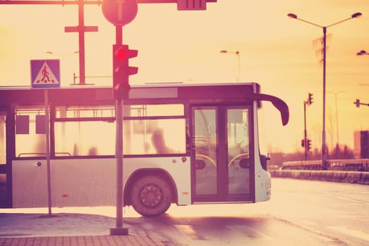 Bus moving on the road in city in early morning. View to the traffic with trafficlights and transport