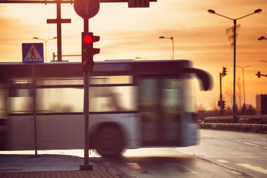 Bus moving on the road in city in early morning. View to the traffic with trafficlights and transport