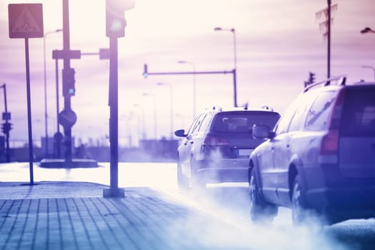 Cars moving on the road in city in early morning. View to the traffic with trafficlights and transport