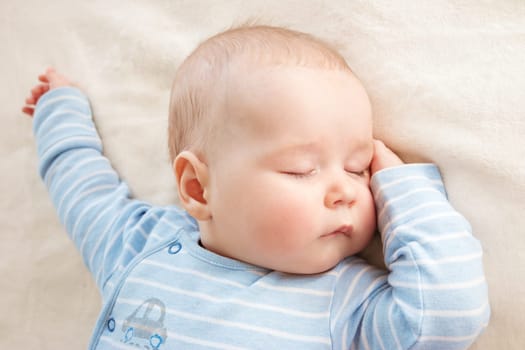 little boy sleeping on soft white blanket
