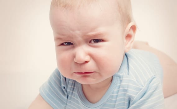 Eight month old baby crying. Sad child portrait