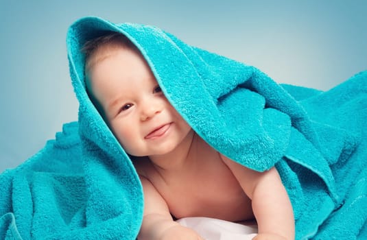 Cute eight month old baby wrapped in a towel