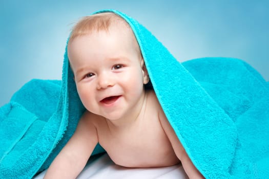 Cute eight month old baby wrapped in a towel