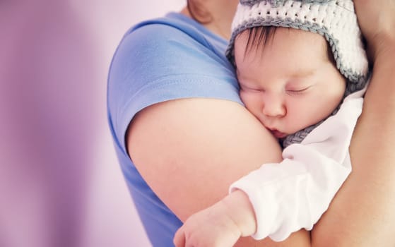 Cute newborn baby girl sleeping. Young woman holding infant child